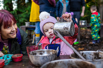 Child at mud kitchen by Adrian Clarke